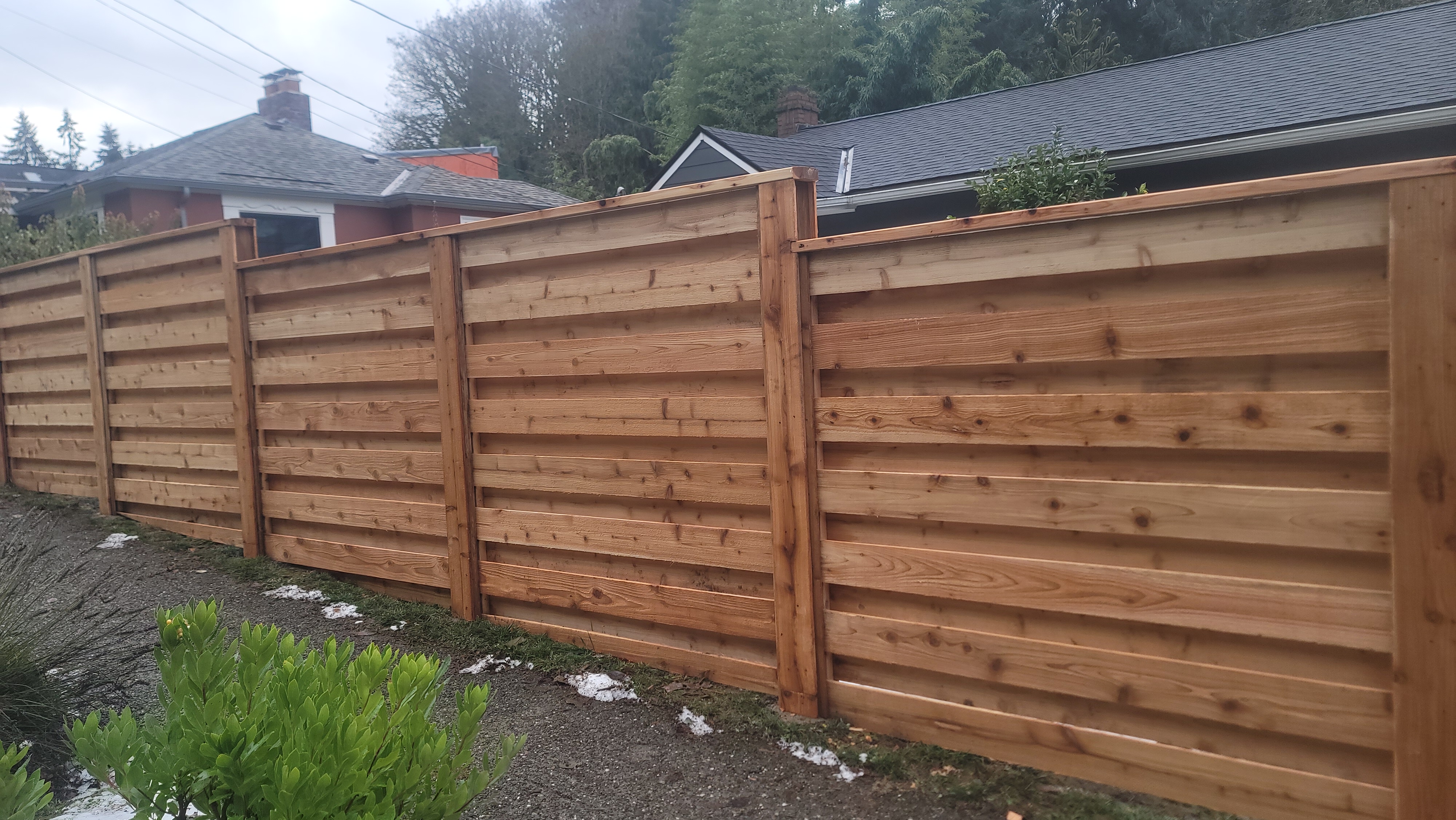 6'FT HORIZONTAL CEDAR FENCE WITH OVERLAPPED BOARDS.