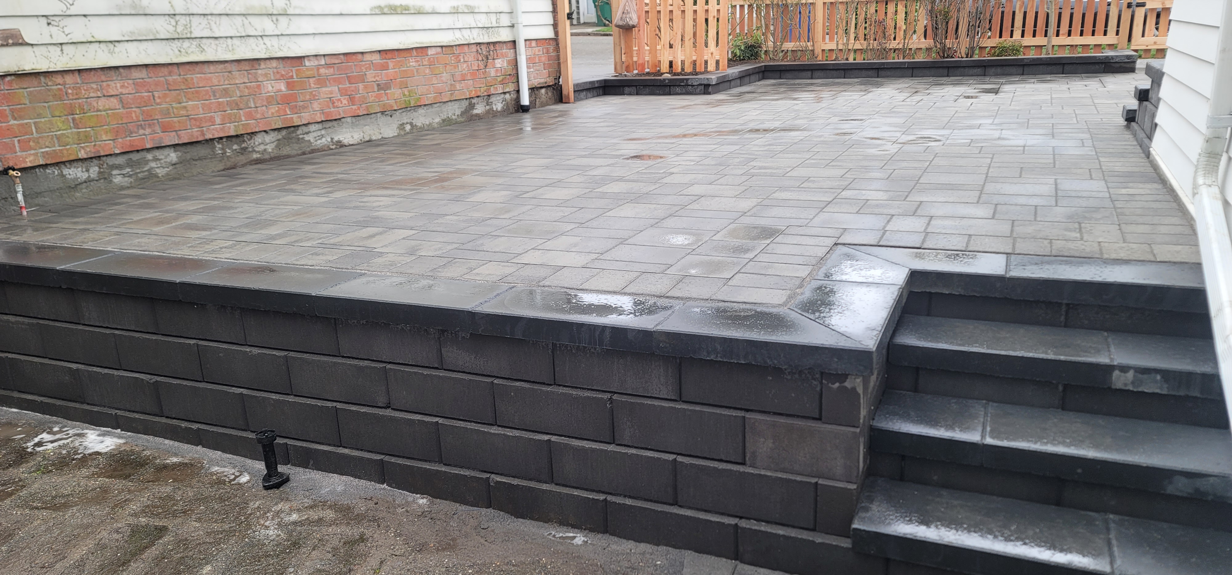 RETAINING WALL WITH MANORSTONE BLOCKS WITH SMOOTH FACE CHARCOAL.