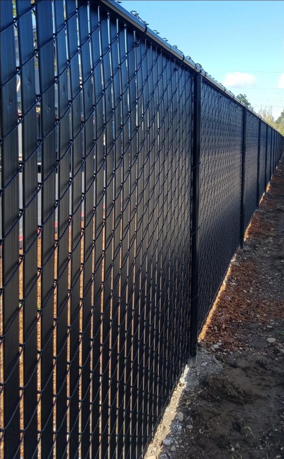 VINYL COATED STEEL CHAIN LINK FENCE BLACK WITH PRIVACY SLATS.