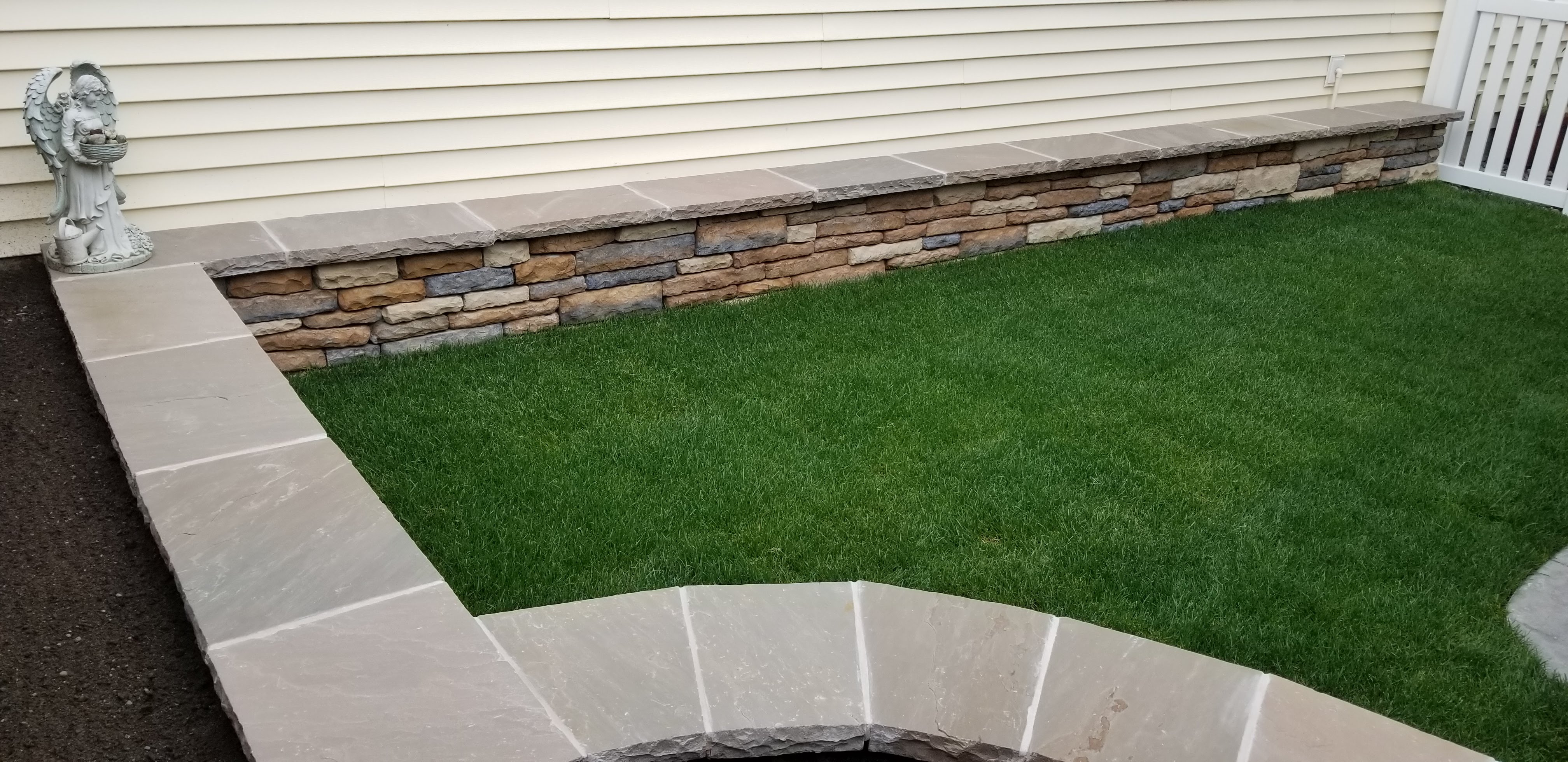 RETAINING WALL WITH CINDER BLOCKS FINISHED WITH CULTURED STONE.