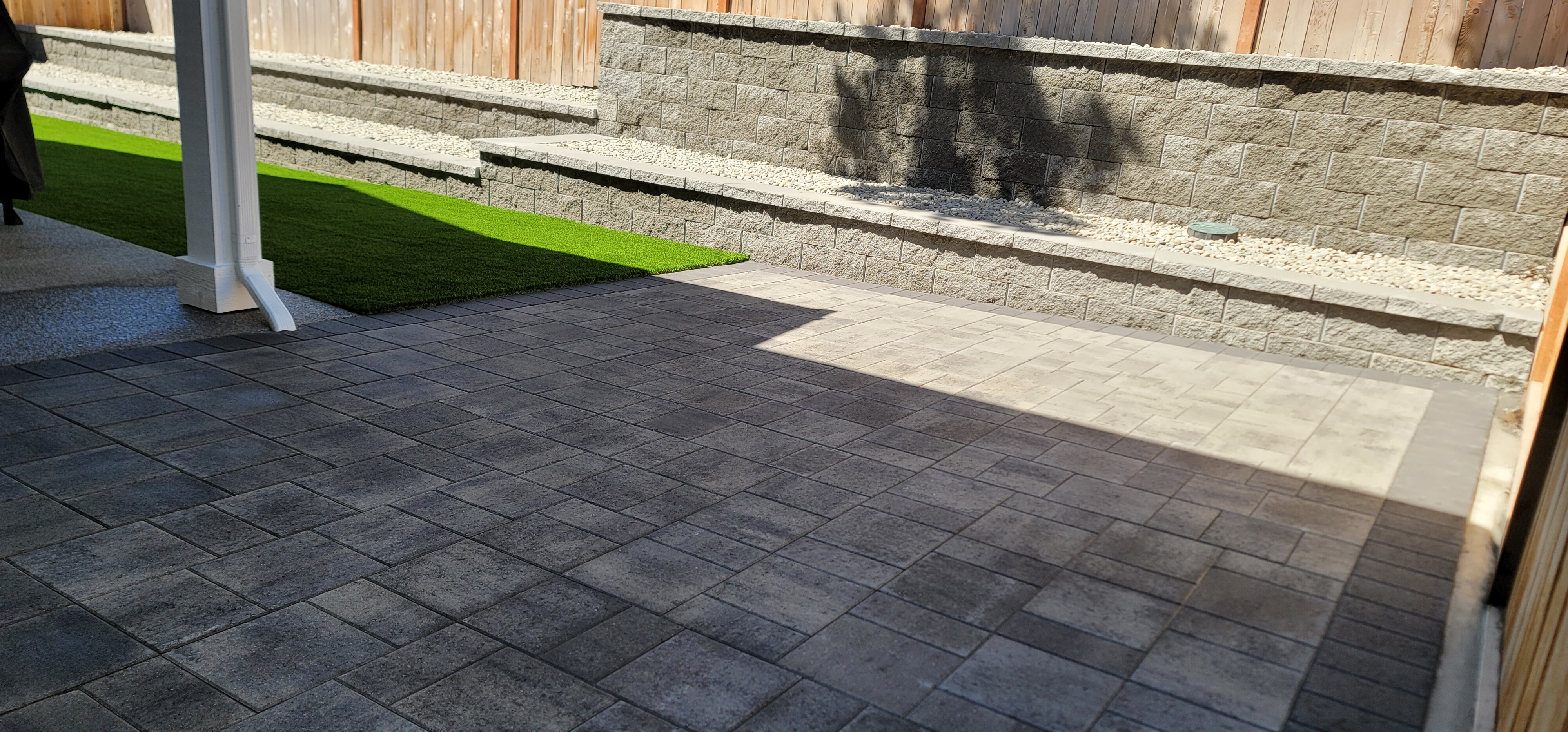 PATIO WITH CATALINA GRANA SLABS AND RETAINING WALLS WITH CORNERSTONE BLOCKS.